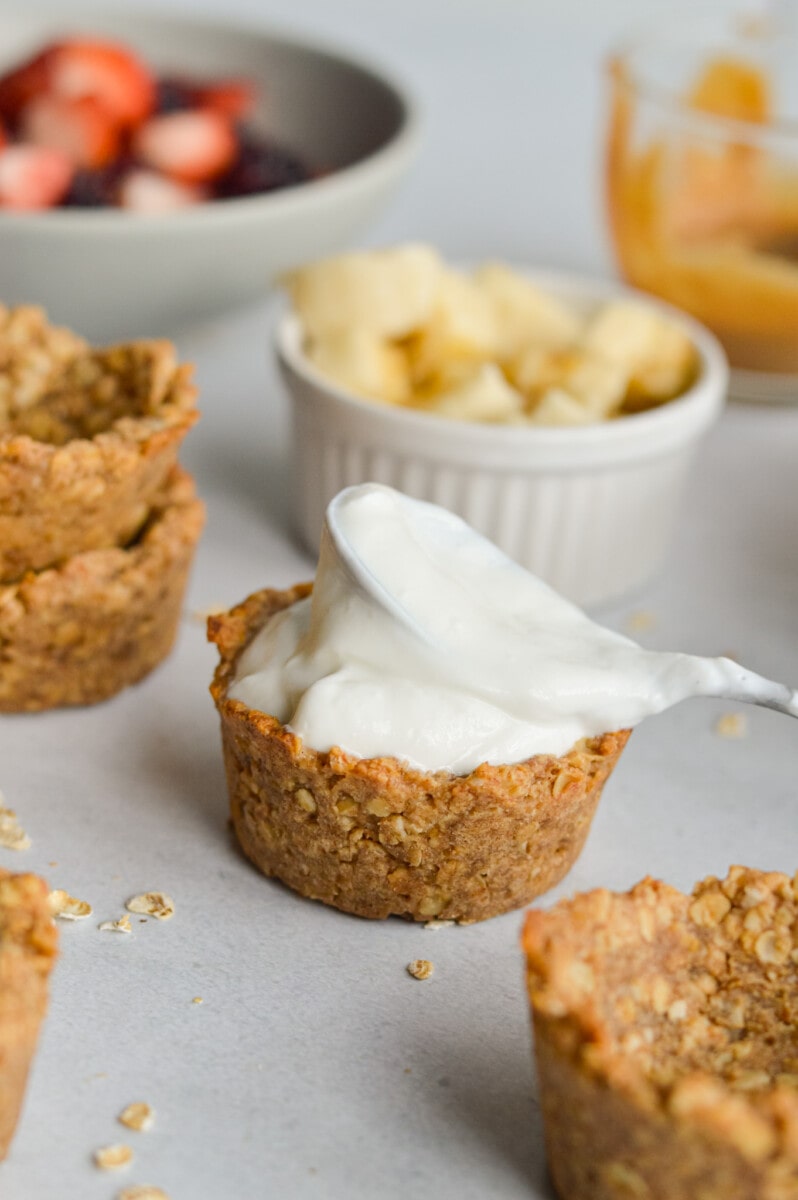 Filling granola cups with yogurt and toppings.