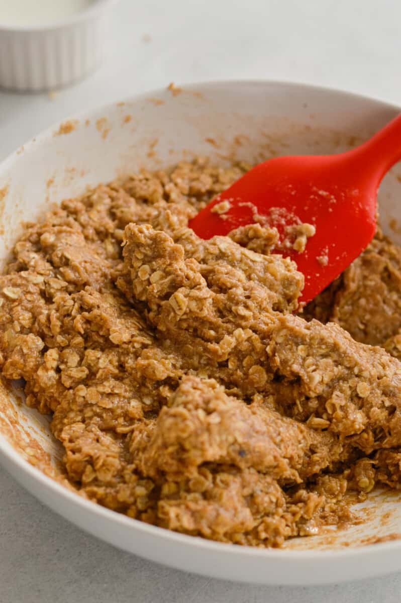 Add oats, oat flour, cinnamon and salt to wet ingredients and mixing to form granola cup mixture.