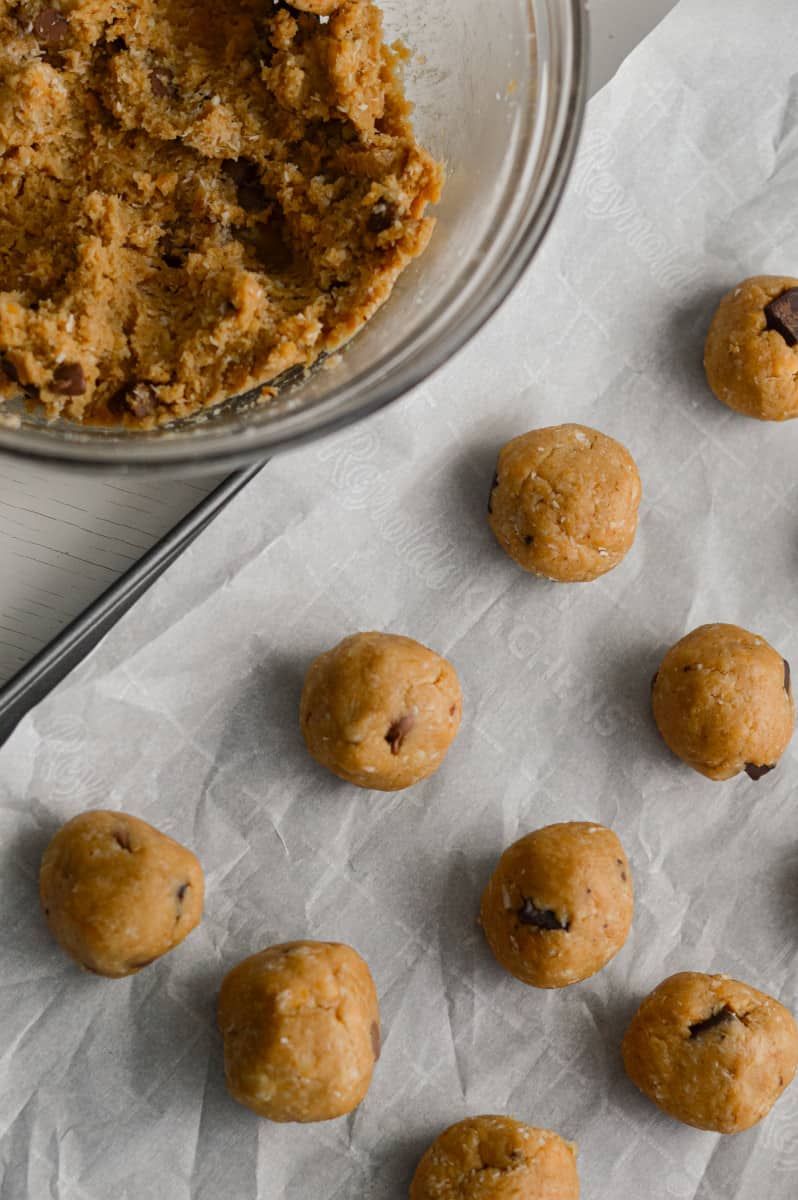 Rolling out no bake cookie dough bites on a tray.