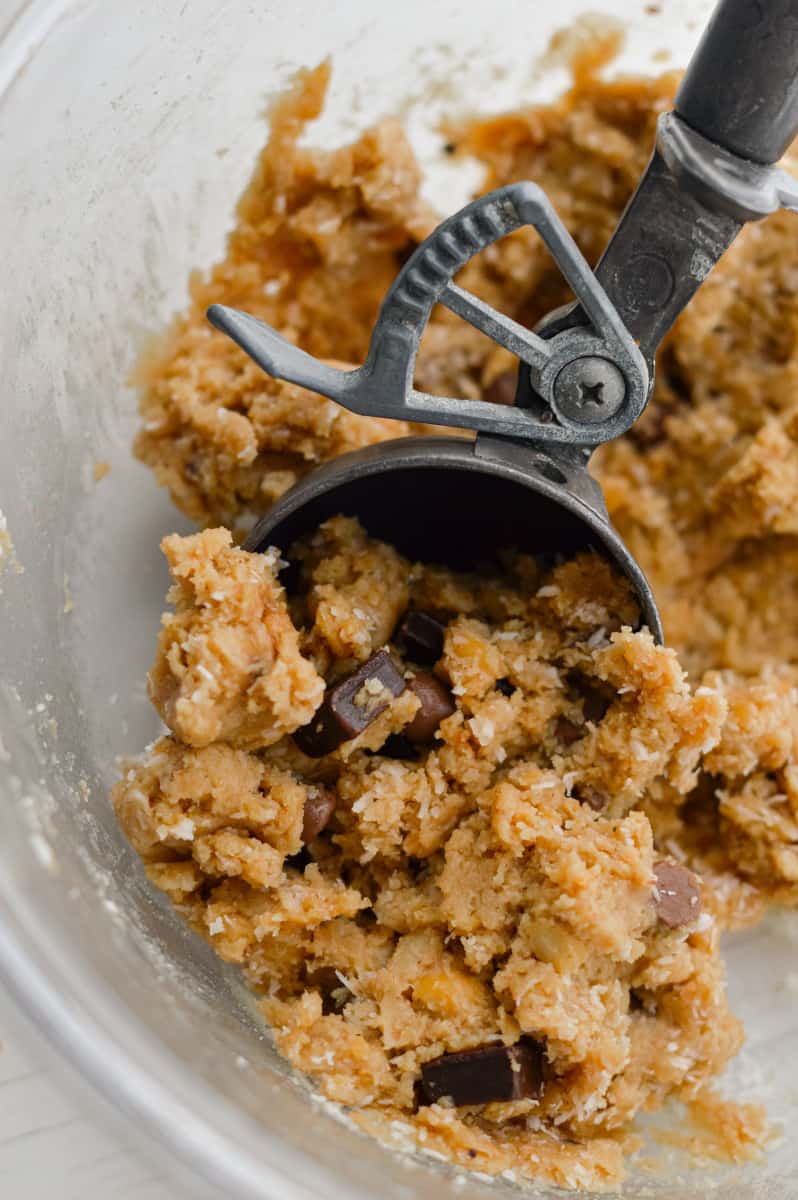 Scooping cookie dough protein balls.