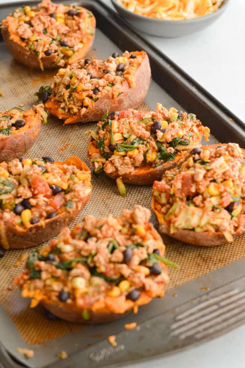 Stuffing sweet potatoes with turkey mixture.