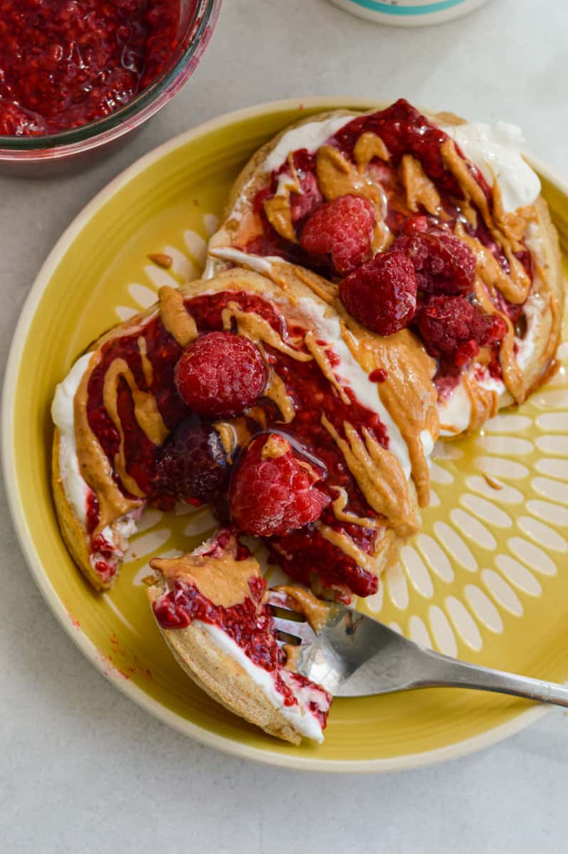 Topping pancakes with peanut butter and raspberry chia jam.