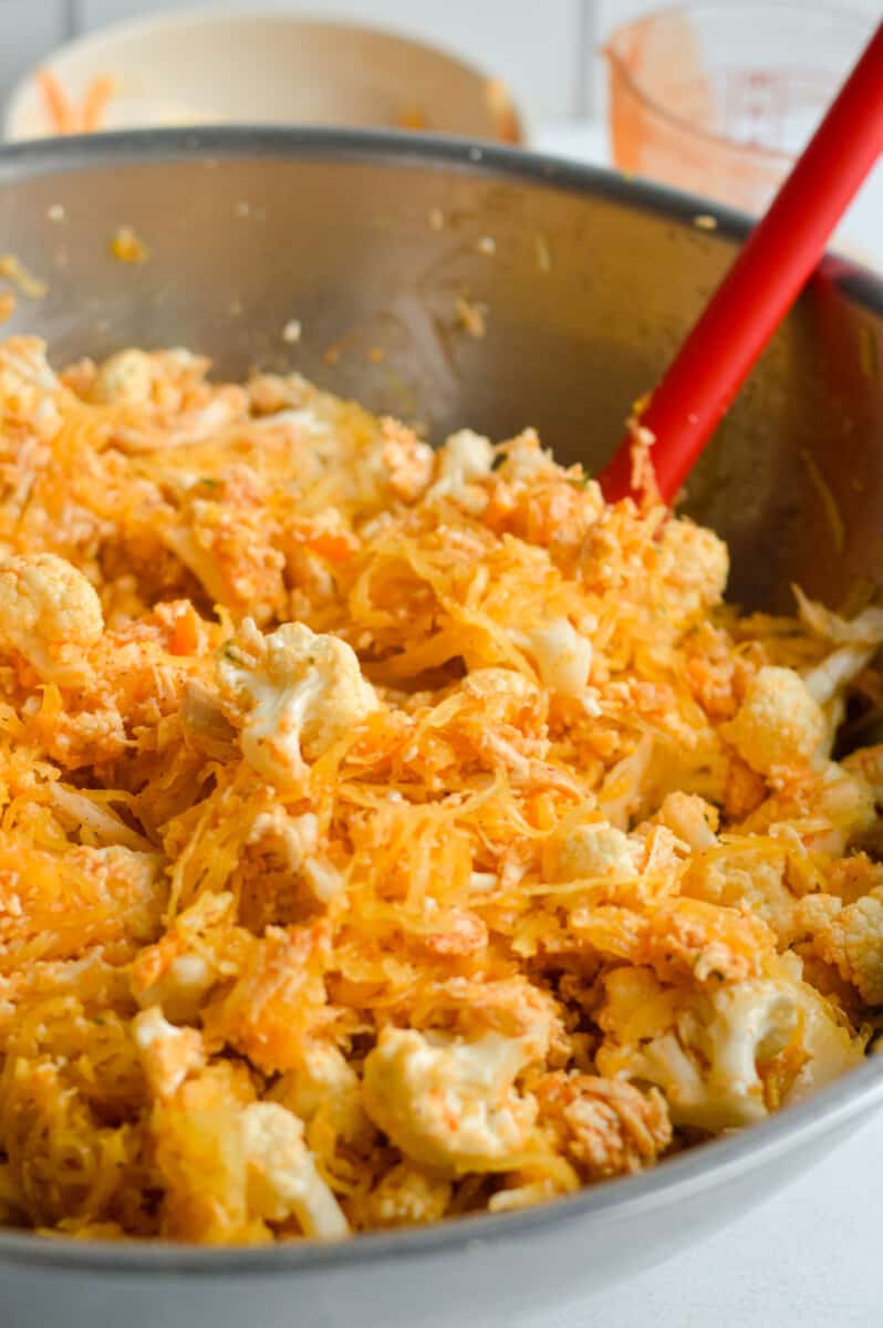 Mixing buffalo chicken spaghetti squash ingredients in a bowl.