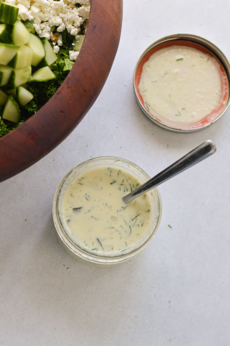 Adding dill pickle dressing to a salad.