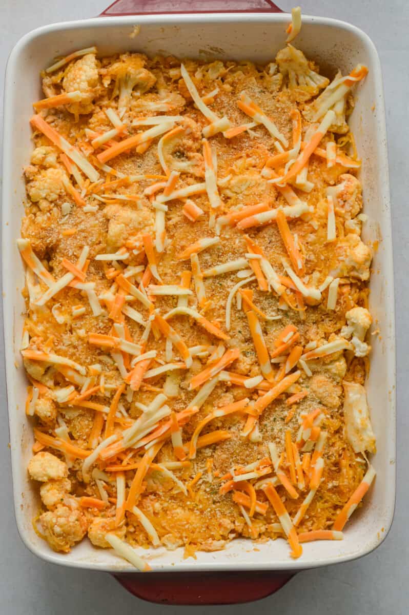 Sprinkled shredded cheese on top of buffalo chicken spaghetti squash casserole.
