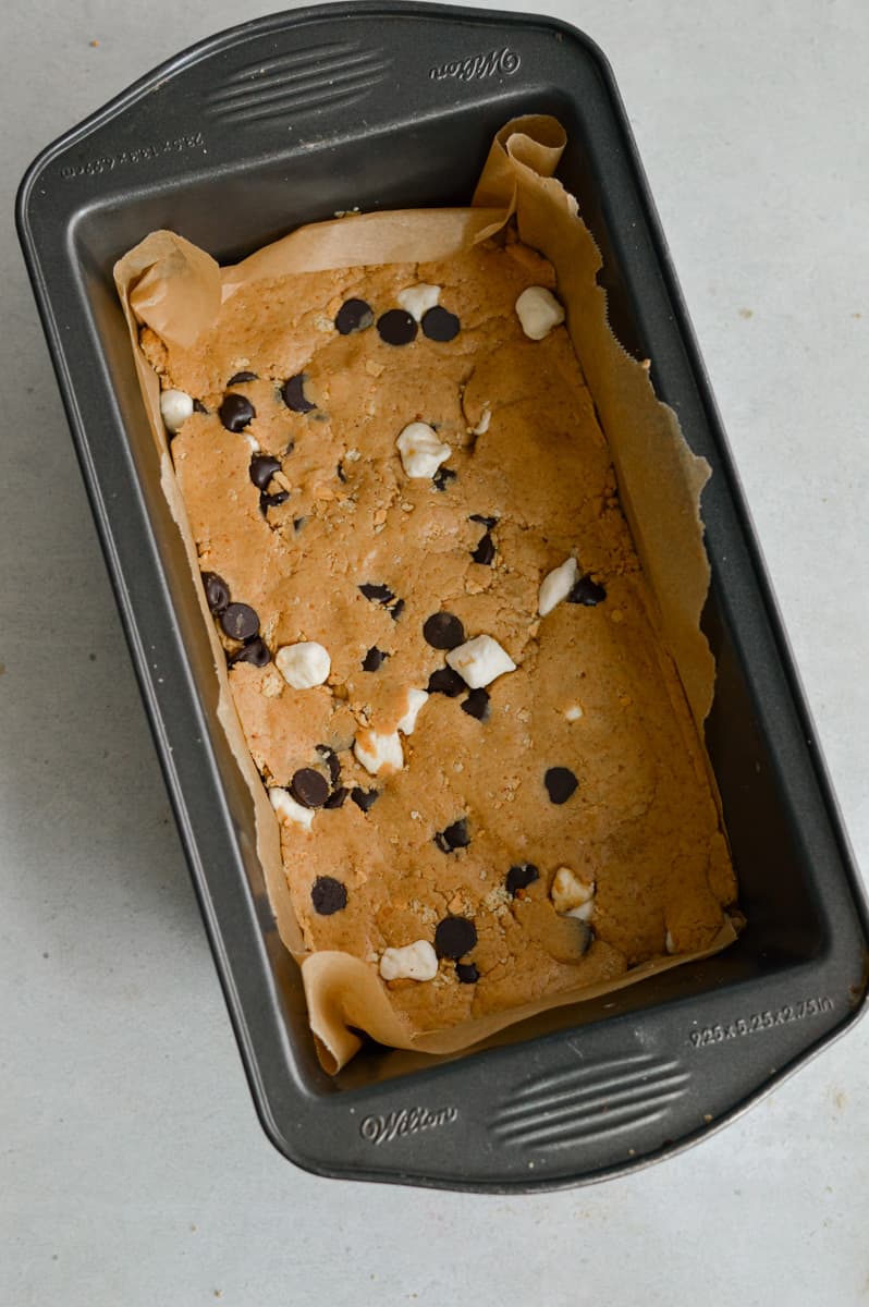 Pressing dough into a loaf pan.