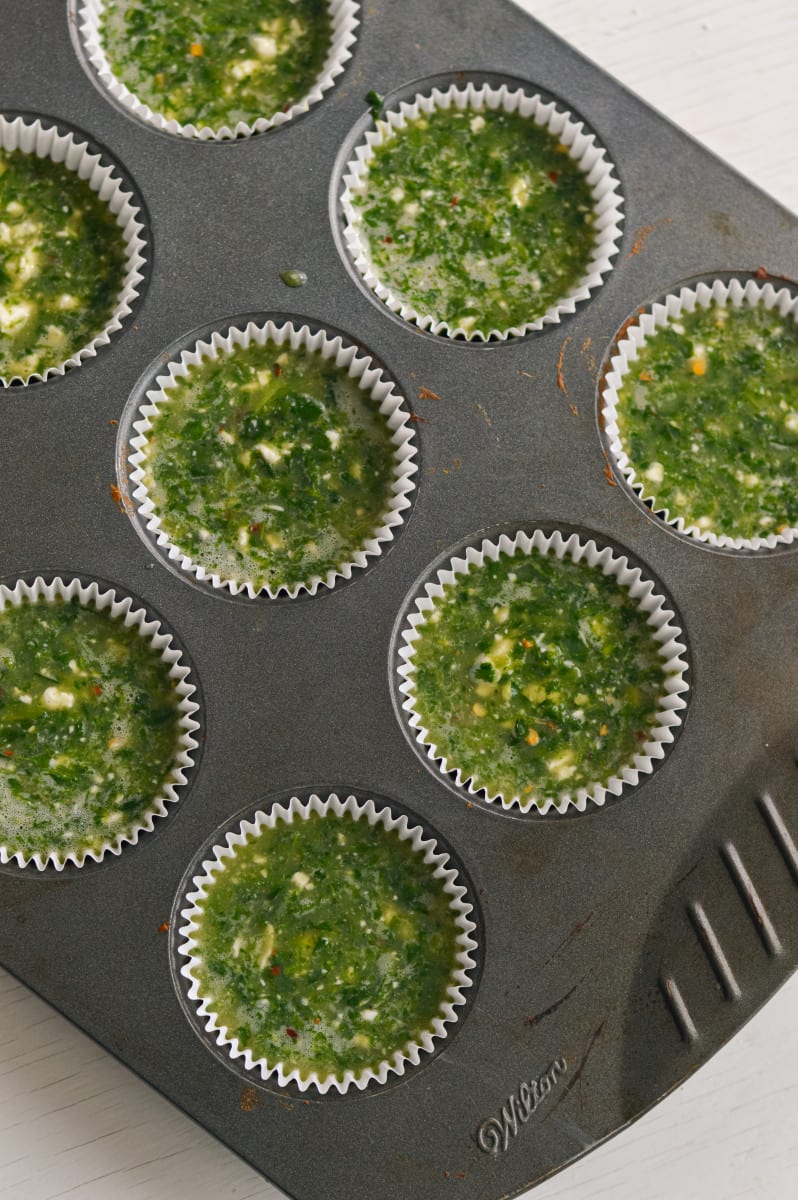 Adding egg mixture to muffin tray.
