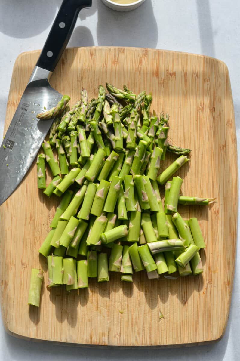 Chopping asparagus on a cutting board.