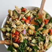 Bowl of chicken pesto pasta salad being mixed.