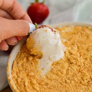 Dipping a strawberry in high protein fruit cheesecake dip.