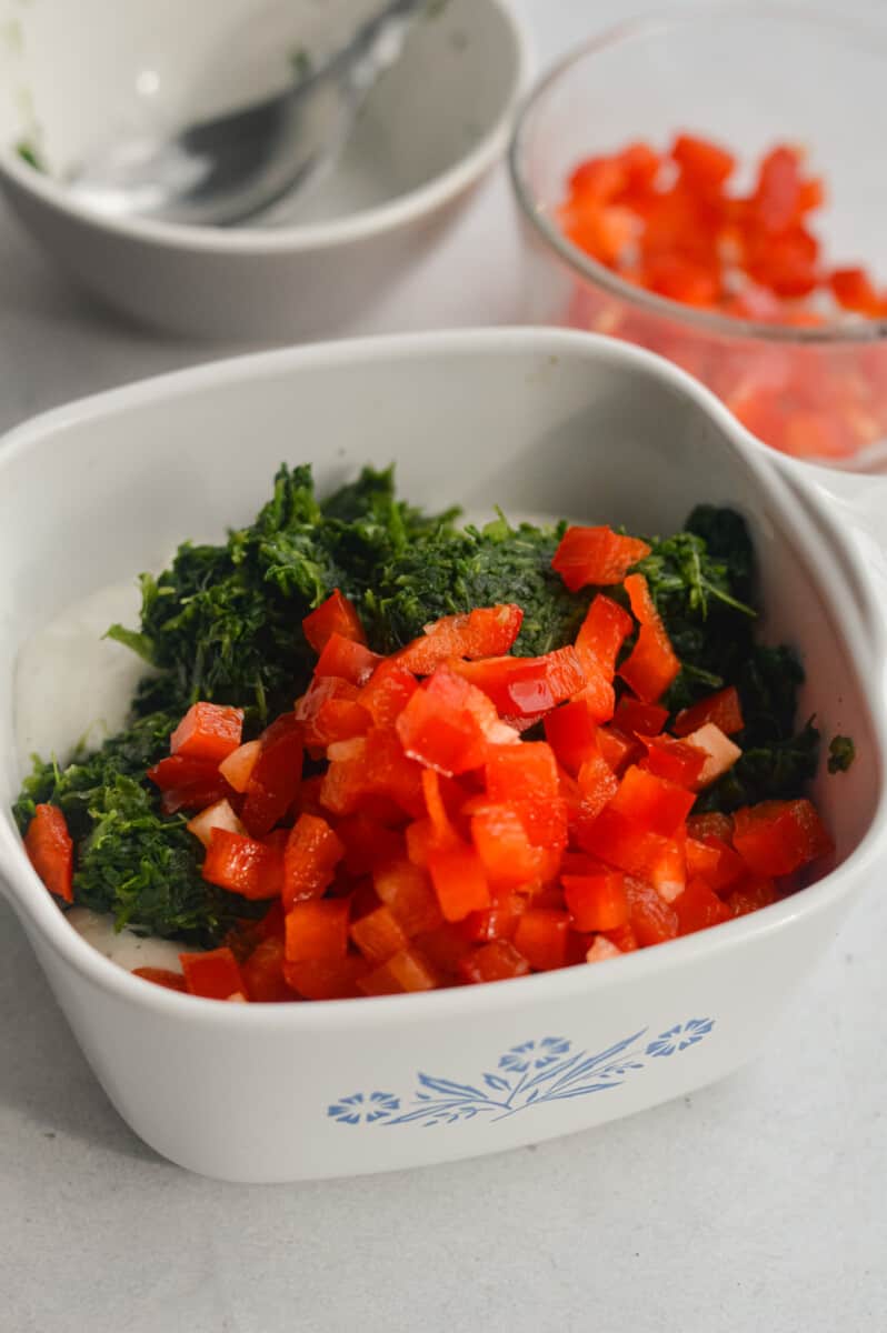 Adding chopped spinach and diced red bell pepper to cottage cheese dip.