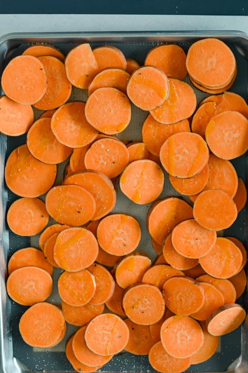 Baking sweet potato rounds on a tray.