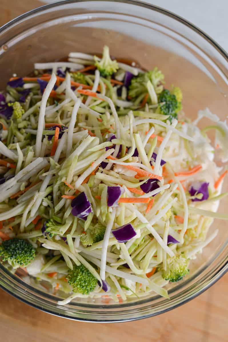 Adding ingredients for chicken salad to glass bowl.