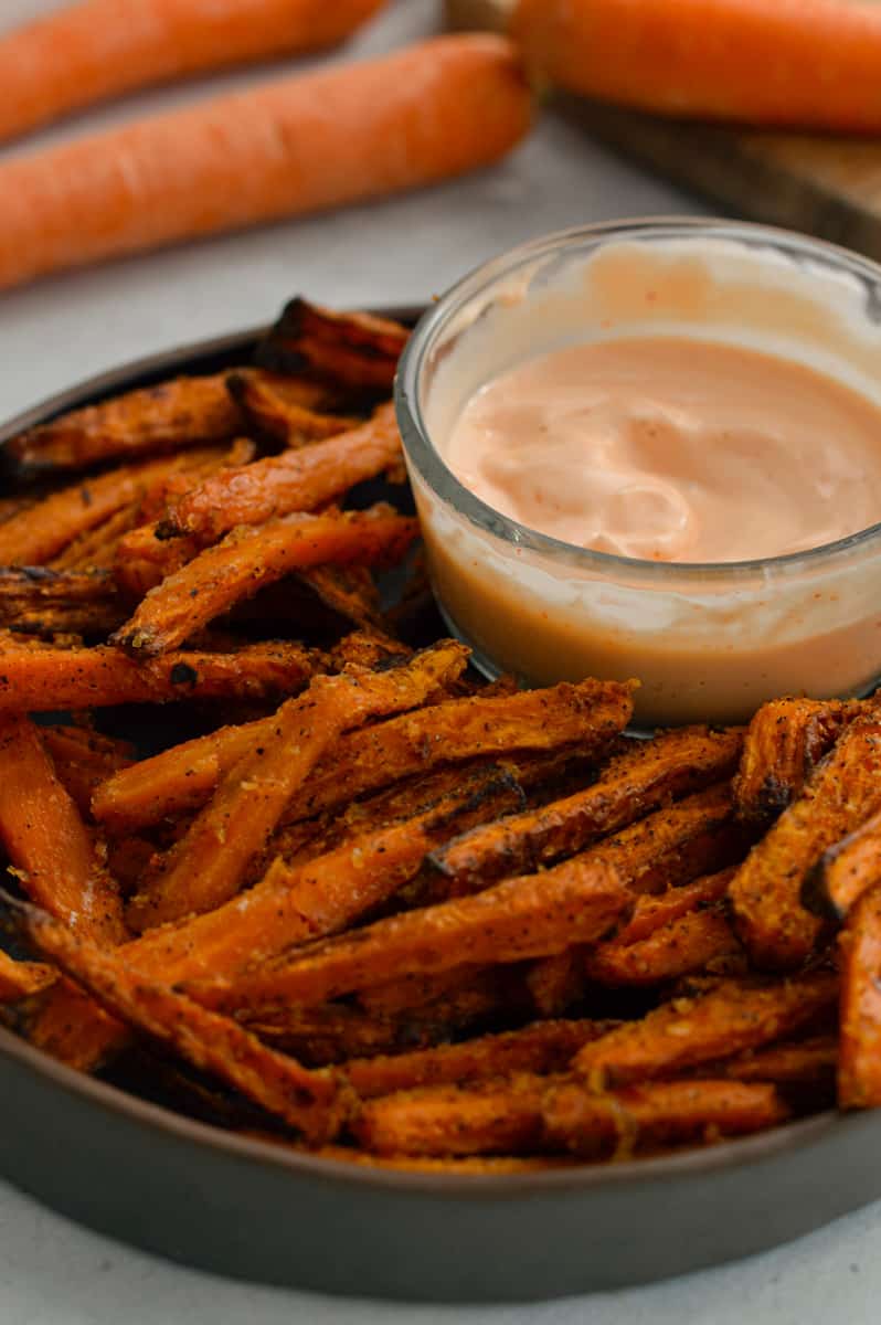 Plate of air fryer carrot fries served with sriracha mayo.