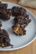Chocolate covered dates on a plate.