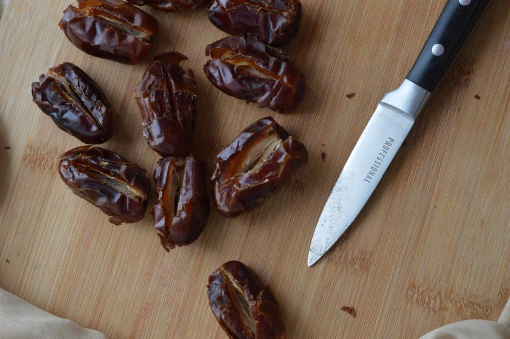 Slicing dates on a cutting board.