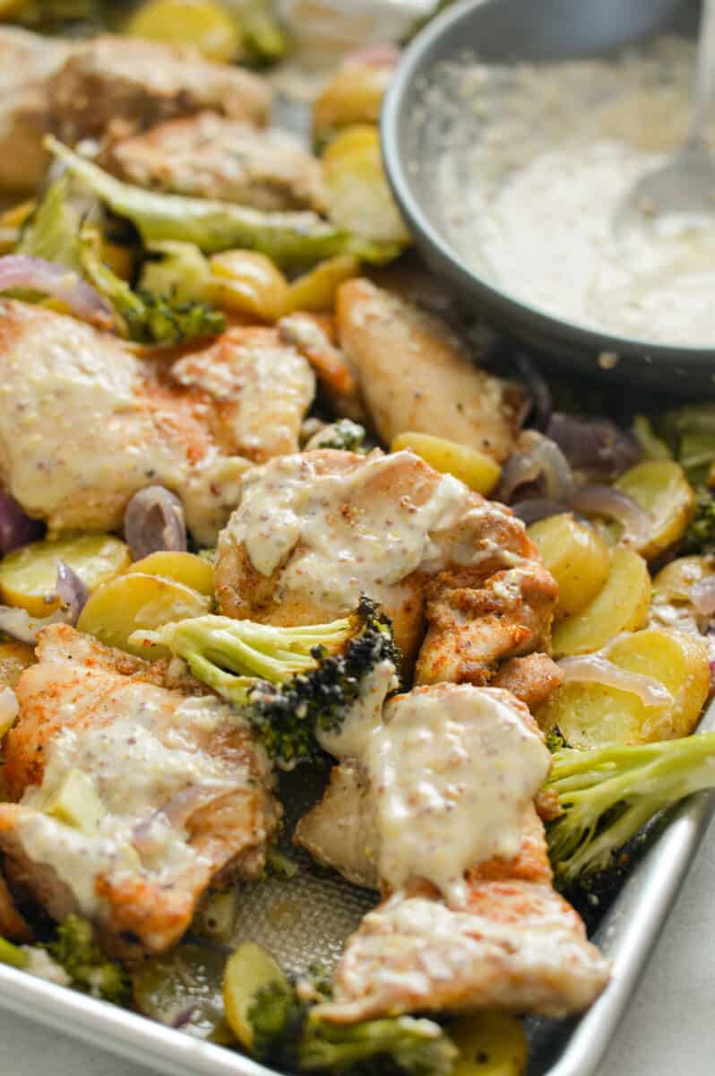 Drizzling honey mustard sauce on chicken, potatoes and broccoli.