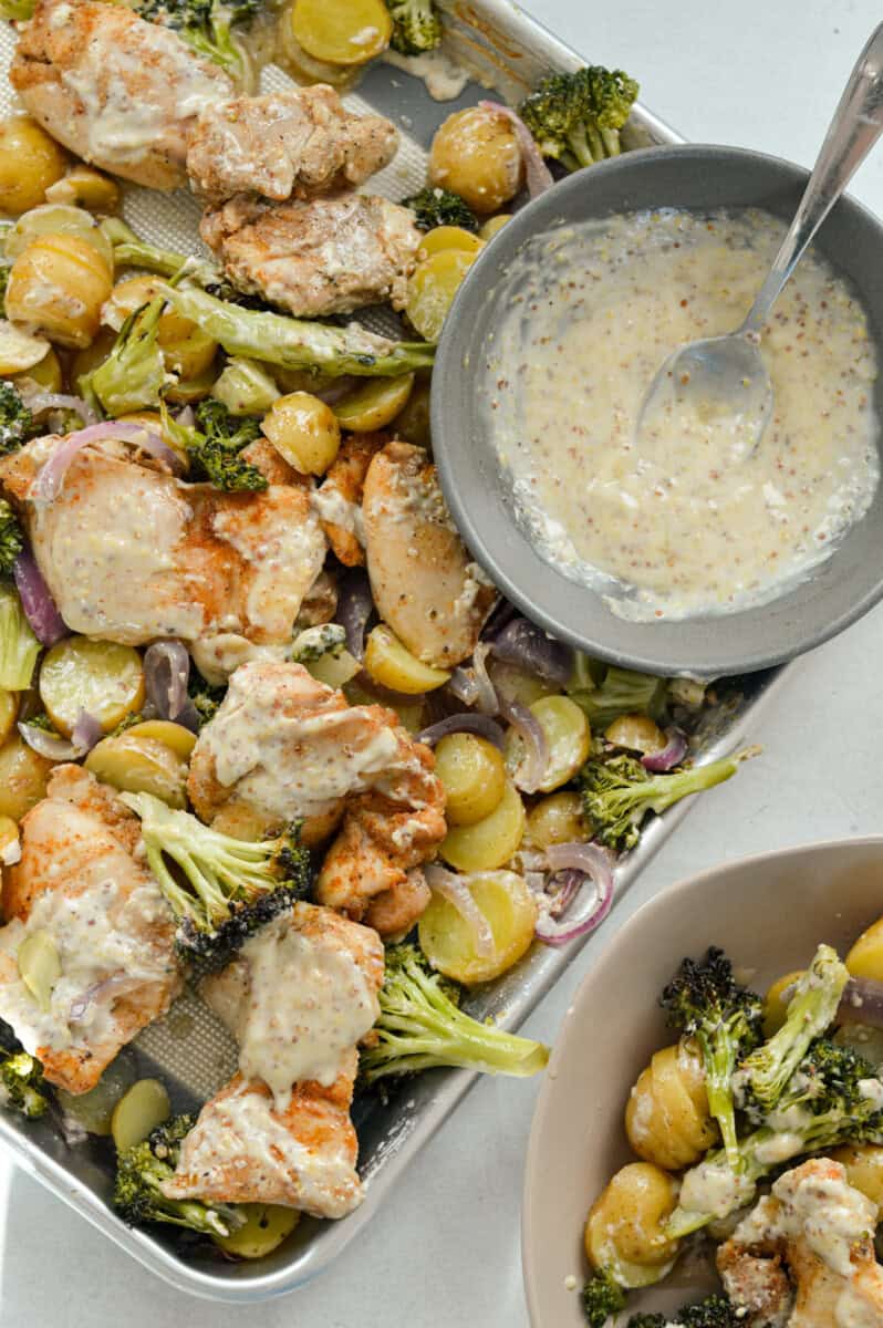 Birds eye of a sheet pan chicken and veggies with honey mustard sauce.