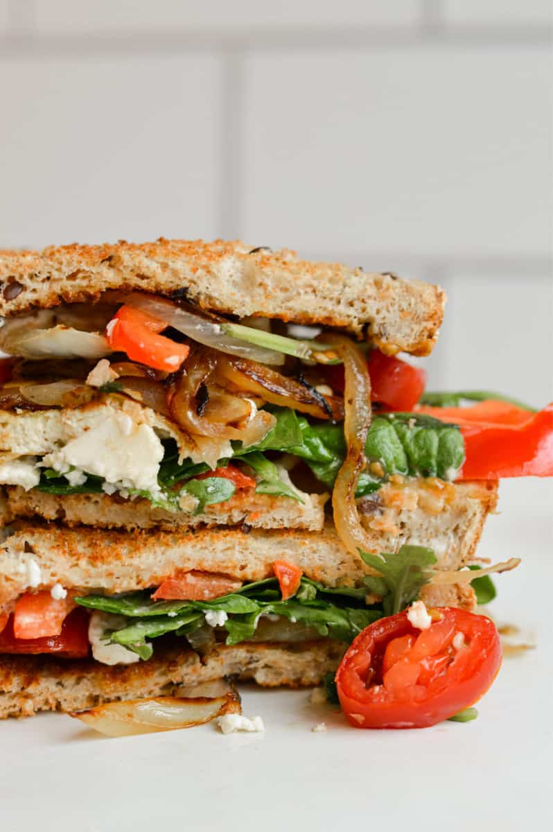 Grilled pesto tofu sandwich cut in half.