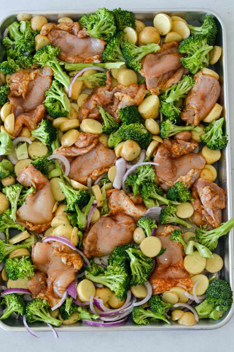 Sheet pan of chicken thighs, broccoli and baby potatoes.