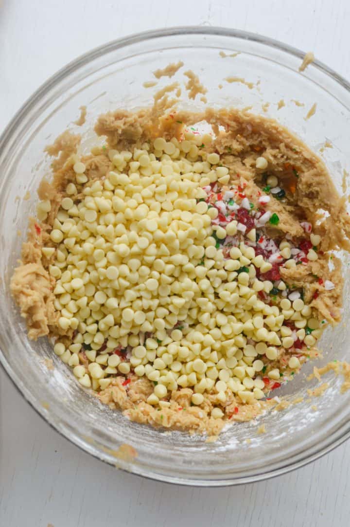 Adding white chocolate chips to cookie dough.