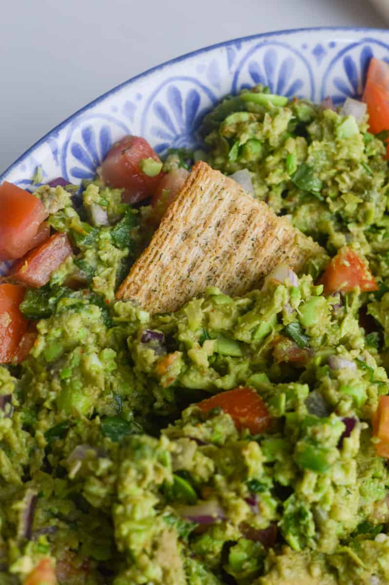 Close-up of edamame guacamole with a cracker.
