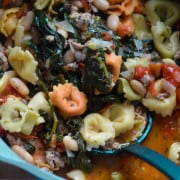 Creamy spinach tortellini soup close-up in a pot.