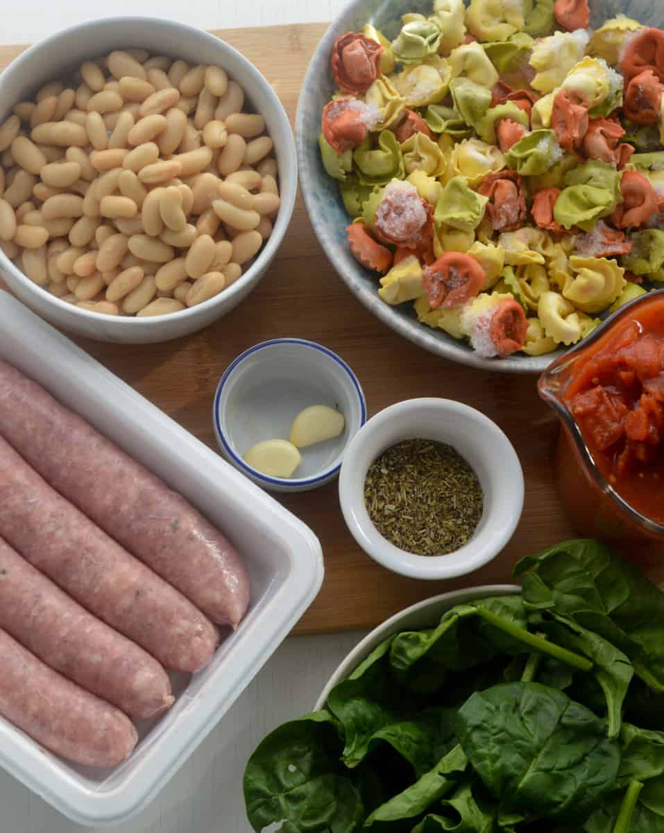 Ingredients for creamy tortellini spinach soup in bowls.  