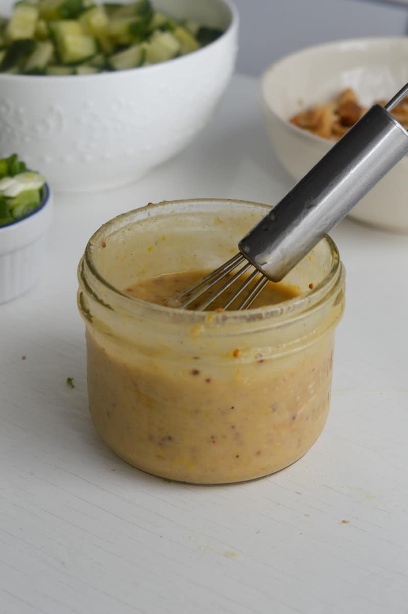 Mixing together tahini dressing.