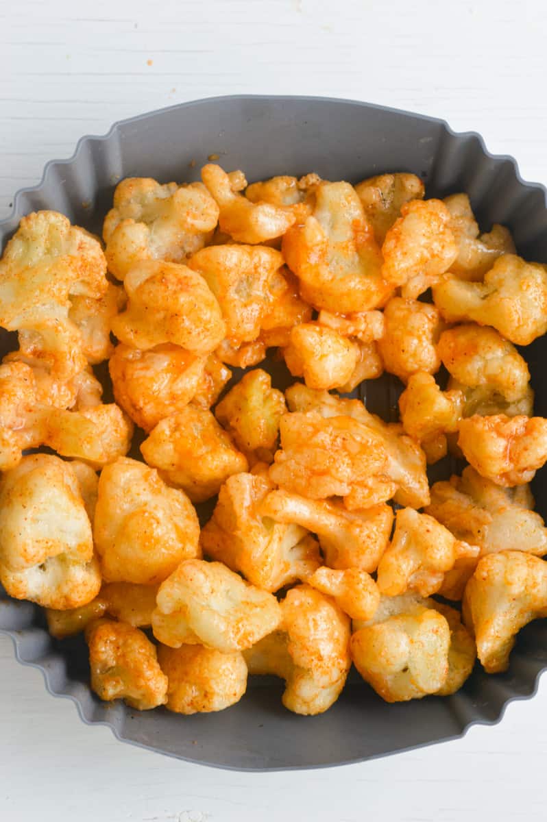 Putting cauliflower in the air fryer.