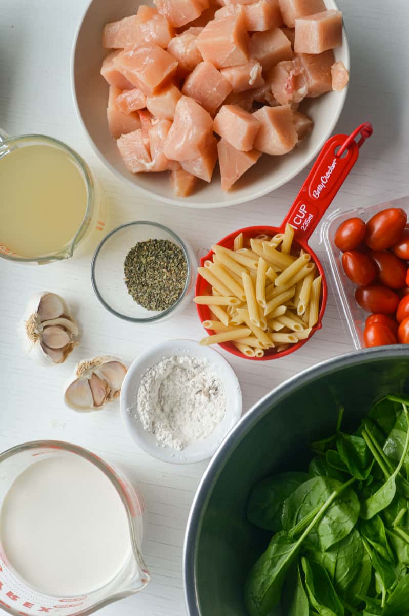 Ingredients for pasta, including chicken, veggies, and cream.