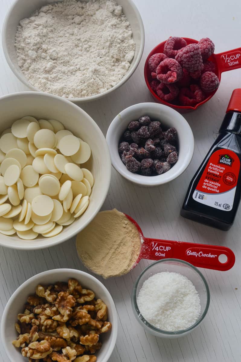 Ingredients for truffles including nuts, protein powder, white chocolate and dates.