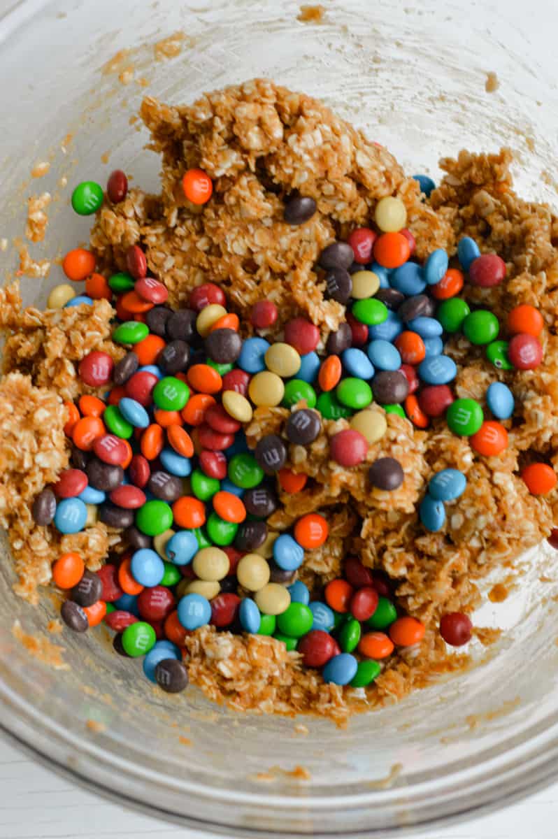 Adding M&Ms into oatmeal balls.