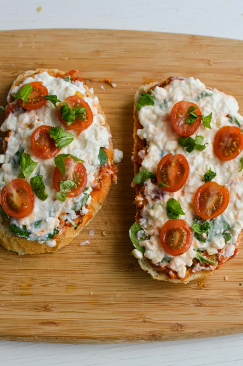 Adding cherry tomatoes and basil on bread.