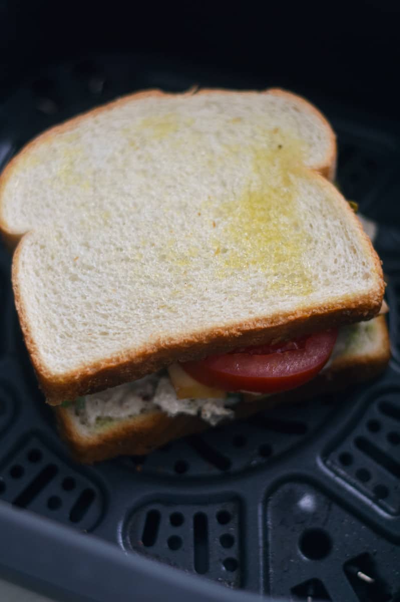 Placing tuna melt in the air fryer.