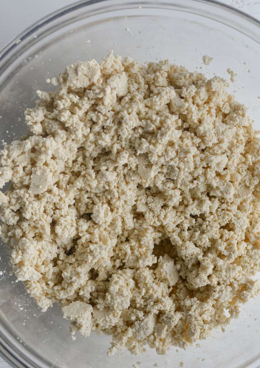 Crumbling tofu in a bowl.