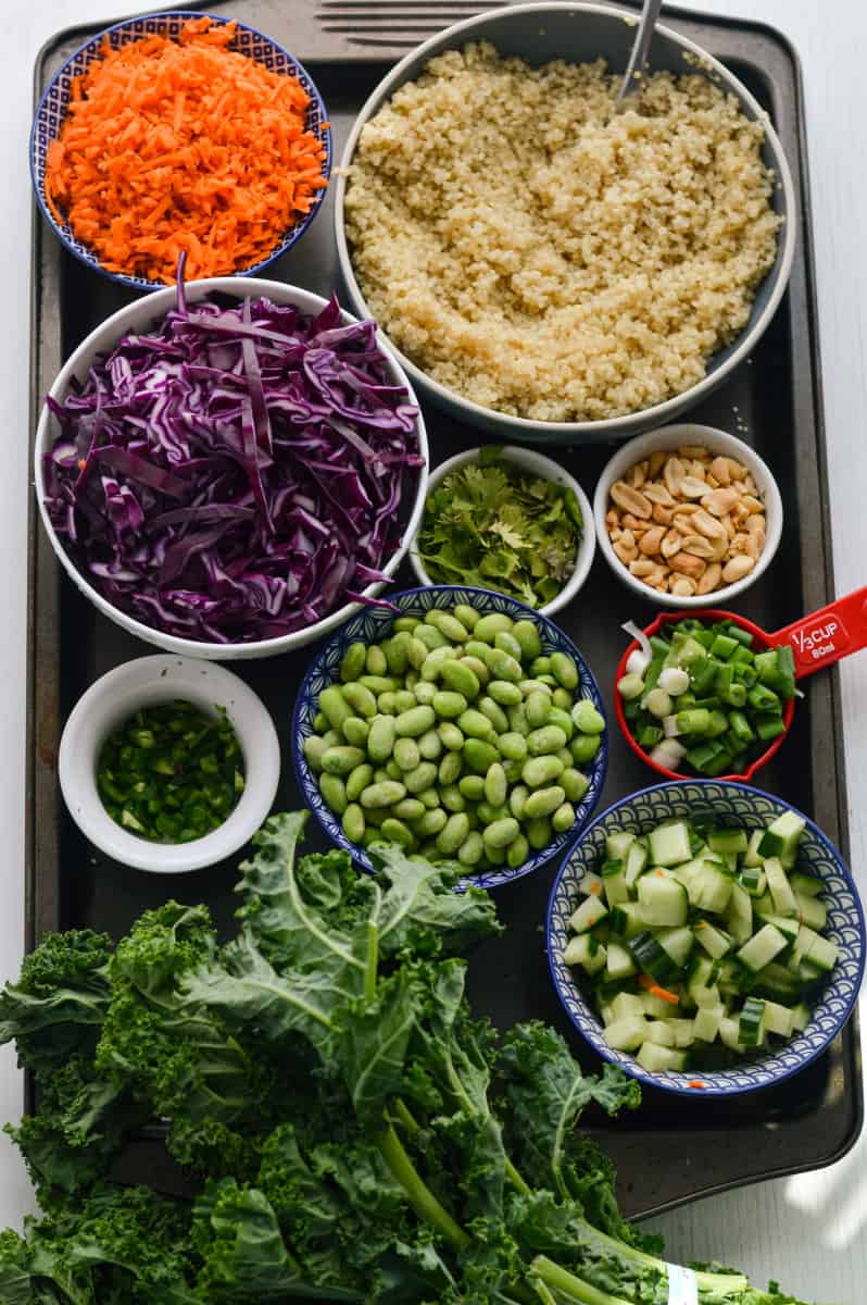 Ingredients for Thai chopped salad on a tray including quinoa, cabbage, kale and more.