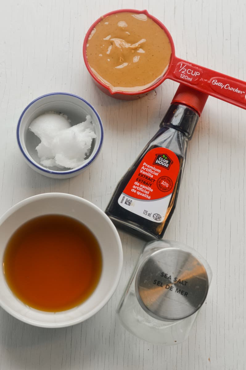 Ingredients for vegan caramel including peanut butter, maple syrup, and coconut oil.