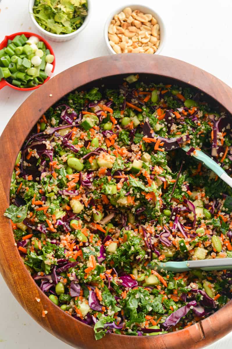 Tossing thai chopped salad and adding green onion, peanuts and cilantro.