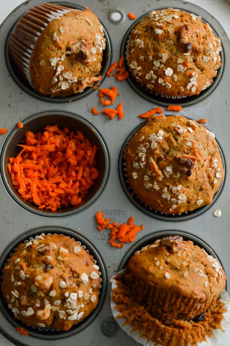 Muffins in a tin with shredded carrots.