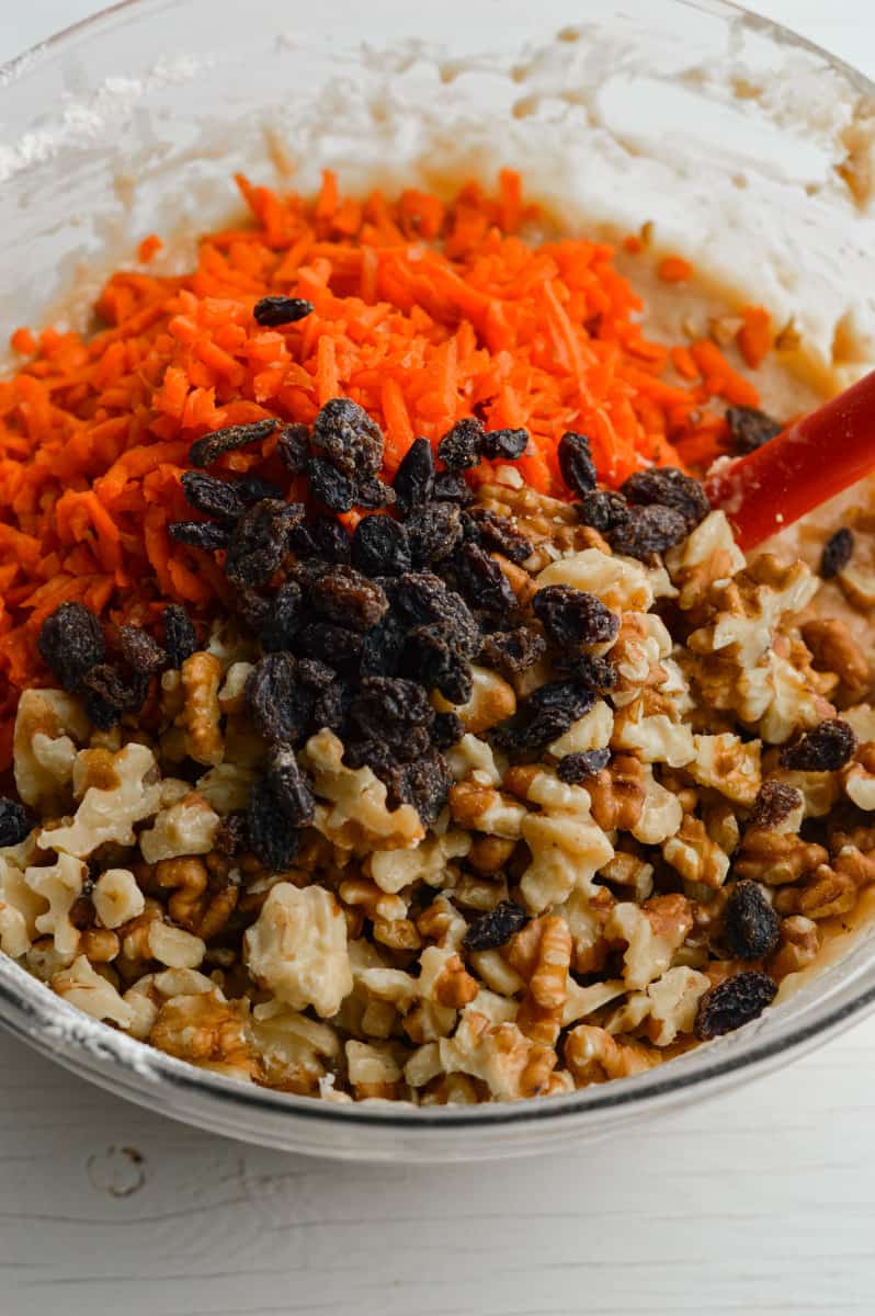 Adding carrots, raisins and walnuts to muffin batter.