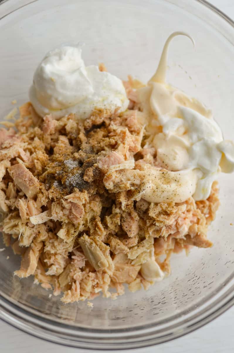 Adding mayonnaise and yogurt to tuna.