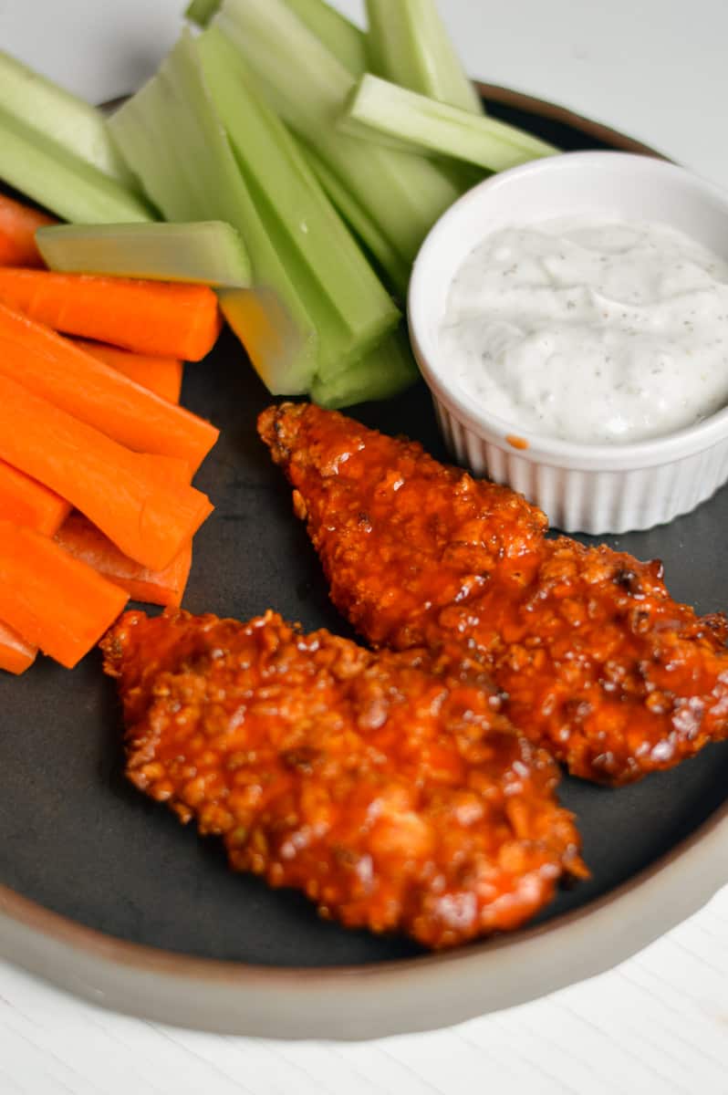 Air fryer buffalo chicken tenders with veggies and dip.