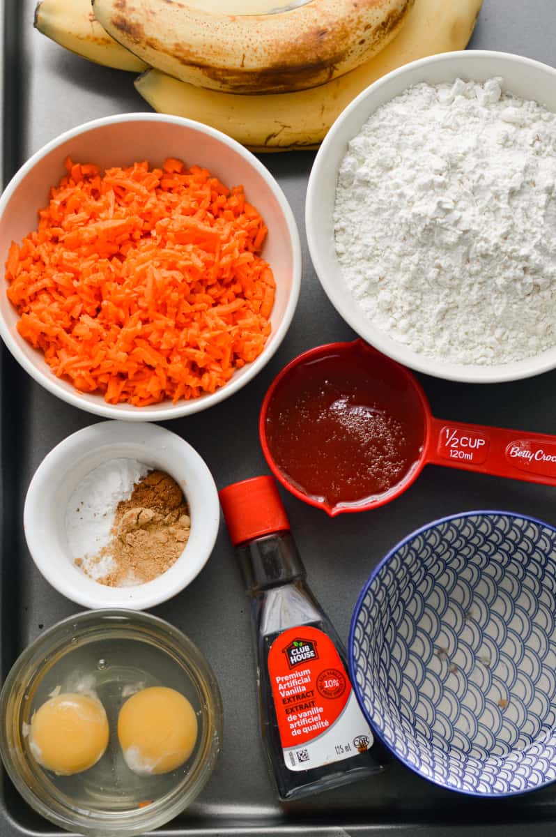 Ingredients for muffins including carrots, flour, eggs and bananas.