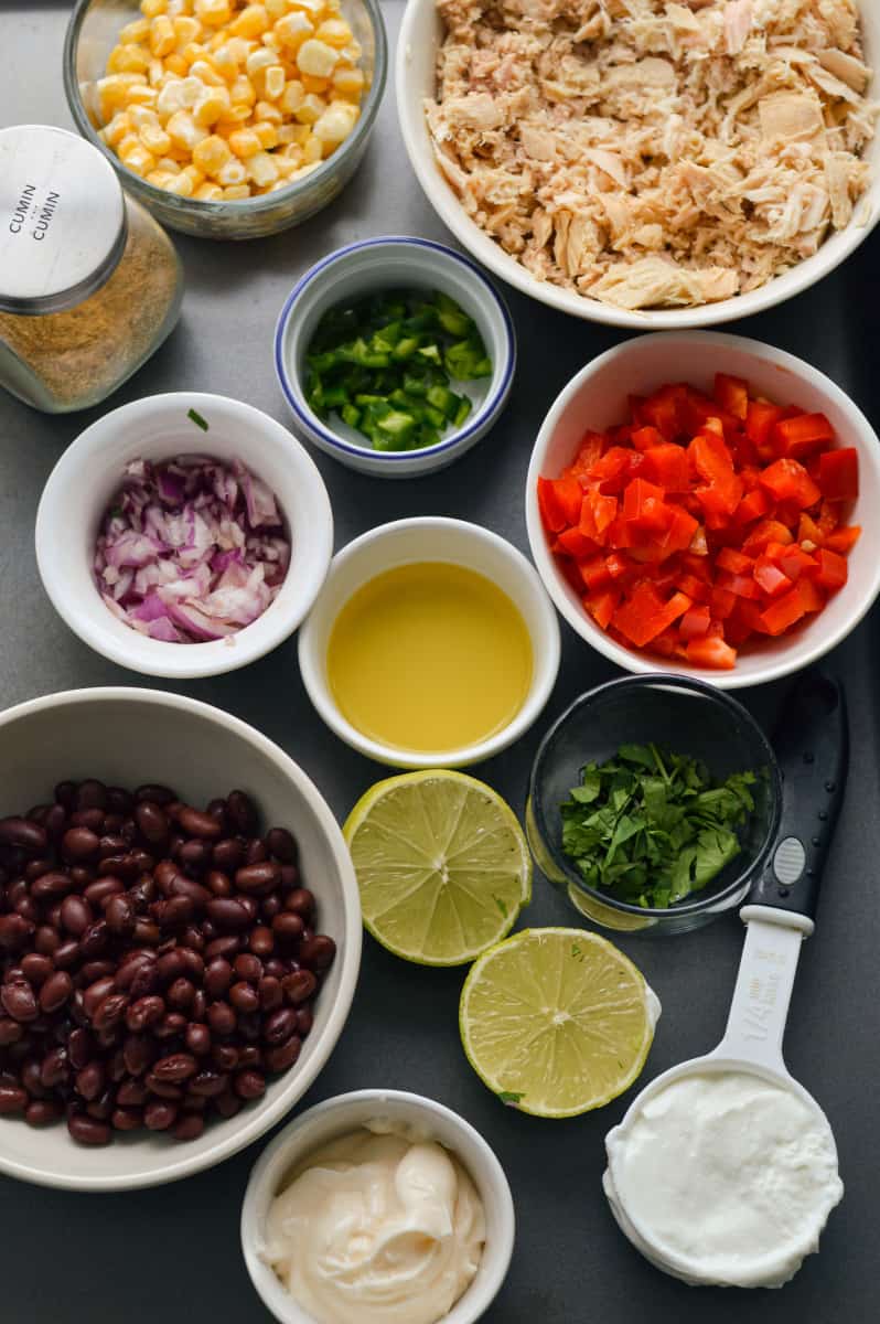 Ingredients for Mexican tuna salad including veggies, black beans and corn.