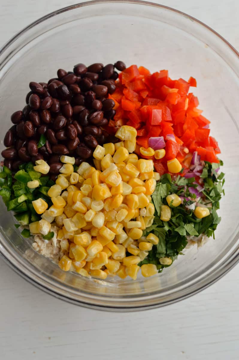 Adding black beans, corn and veggies to tuna.
