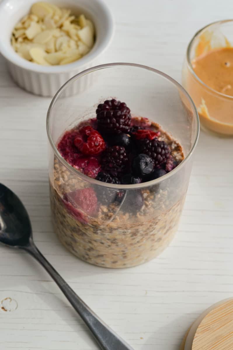Topping overnight oats with frozen berries.