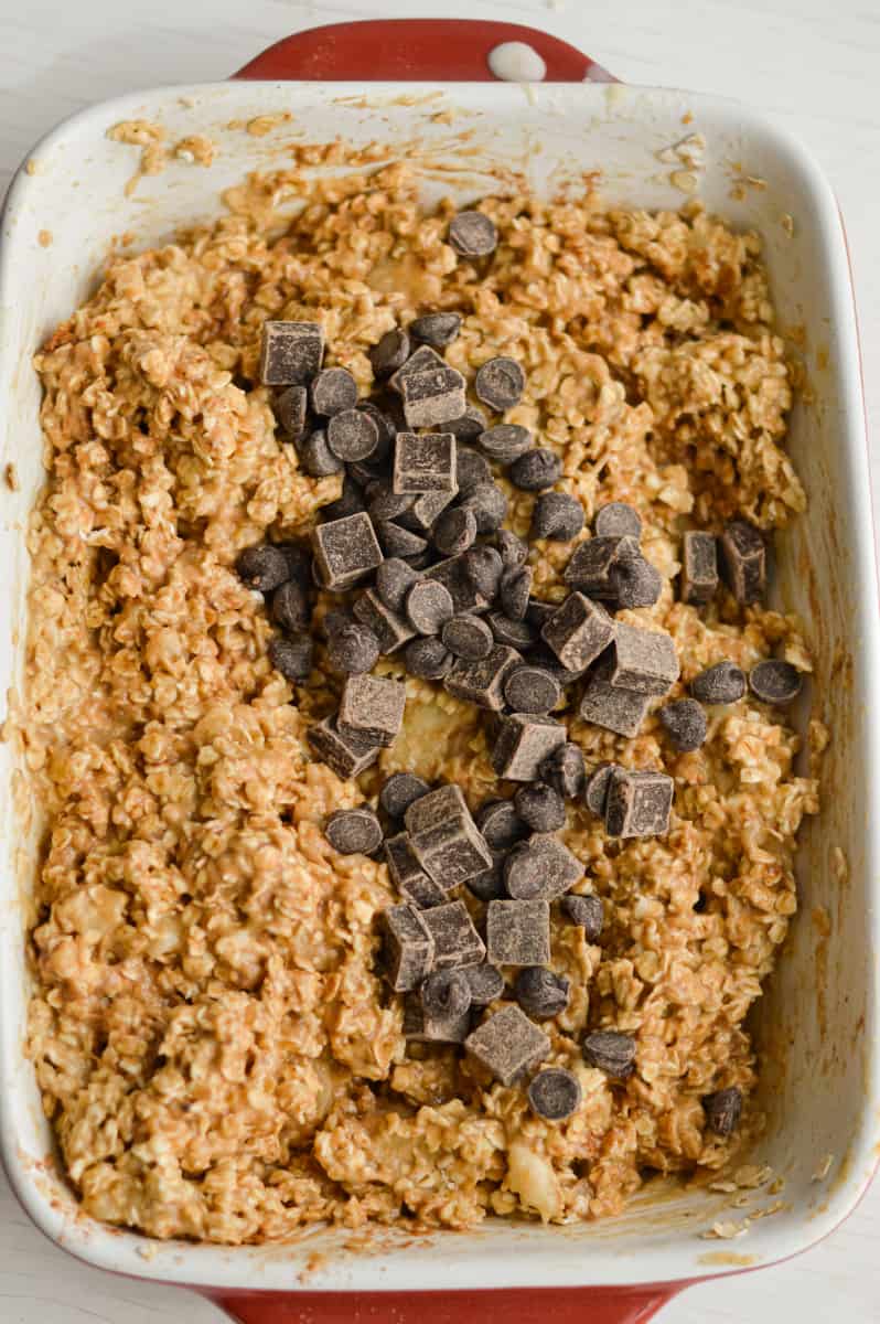 Adding chocolate chunks to oatmeal bars.