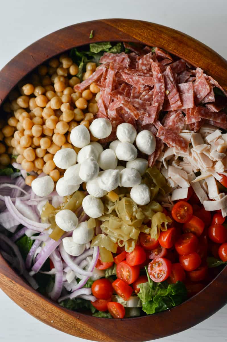 Adding salad ingredients to a bowl.
