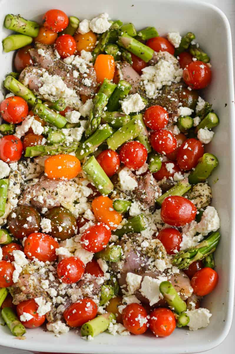 Mixing feta chicken bake in a casserole dish.